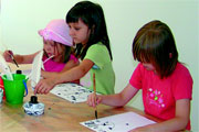 Kinder beim Schreiben mit Pinseln